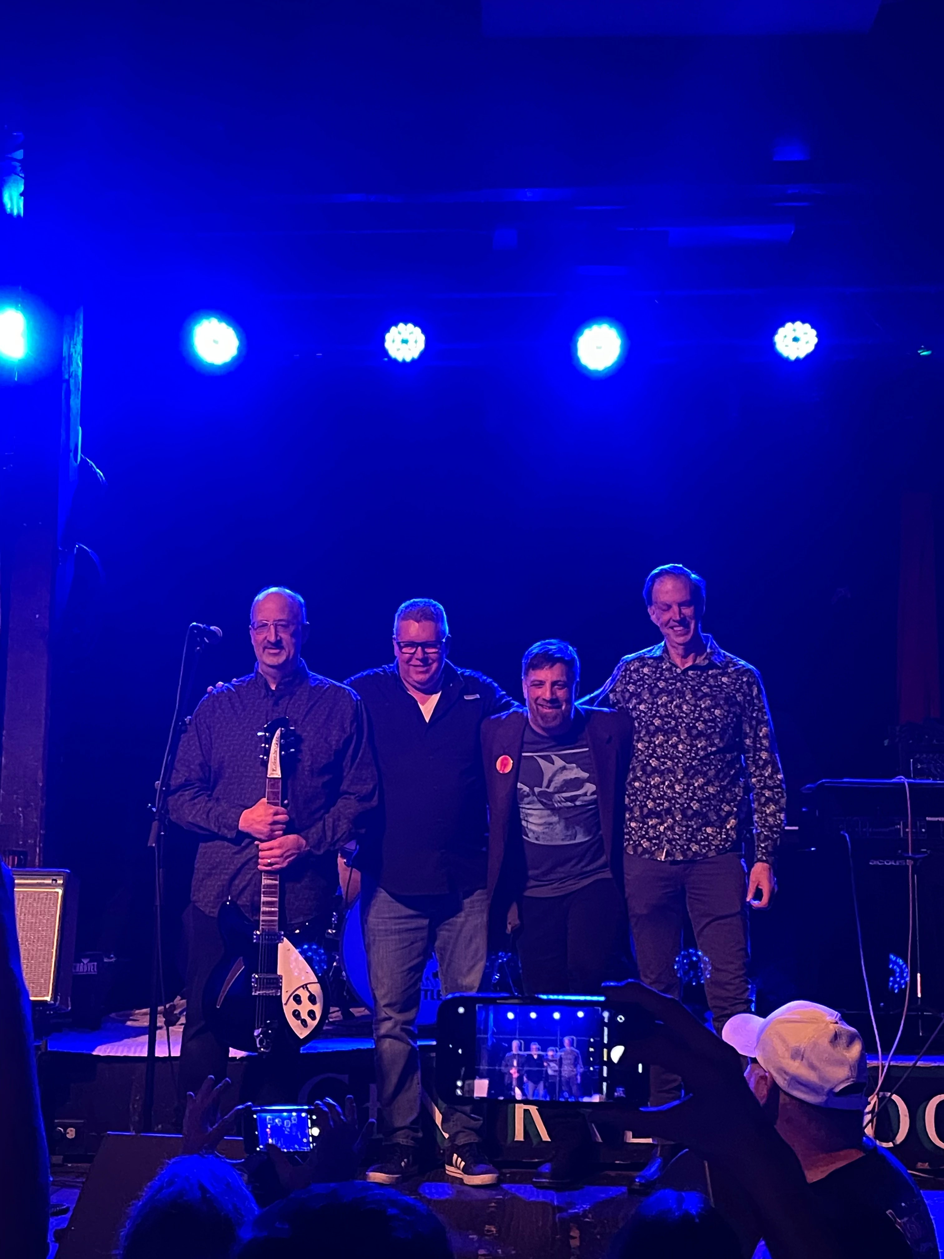 The four members of DRVR.8 together on stage under blue lights at the Central Saloon in Seattle, WA, in spring 2026.